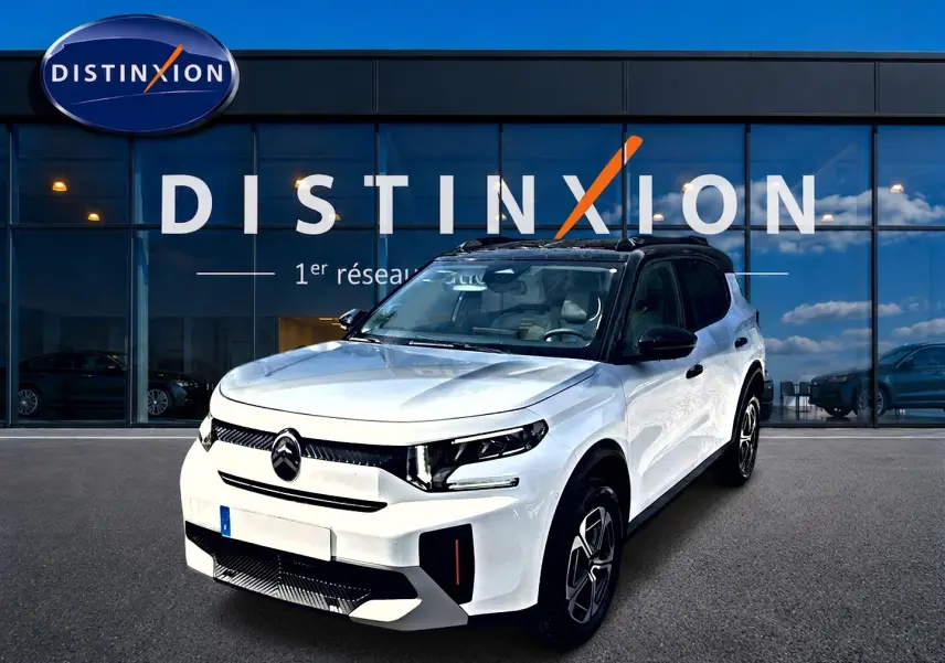 Citroën C3 Aircross blanc vue 3/4 avant droit, toit noir et jantes alu distinctives devant showroom Distinxion.