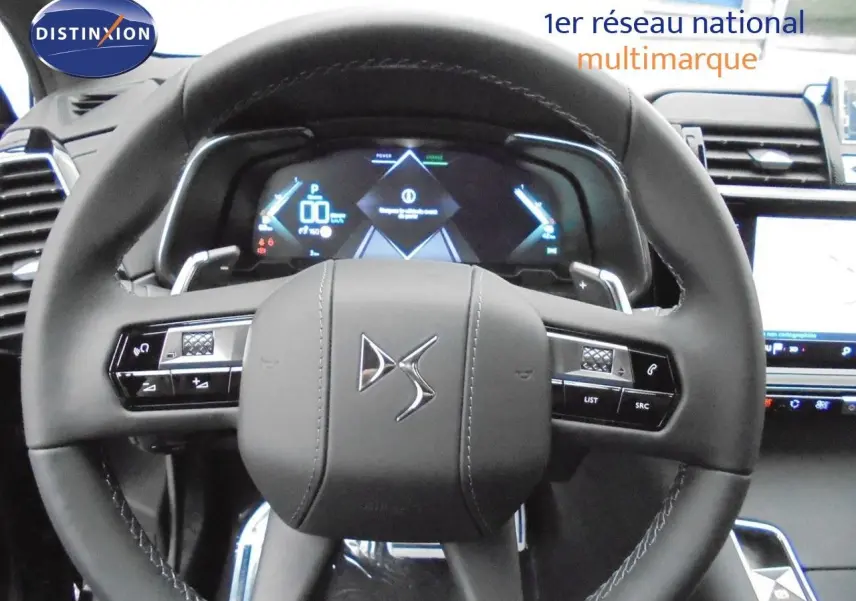 Vue rapprochée du volant DS noir avec commandes intégrées et tableau de bord numérique du DS7 Crossback E-TENSE 2021.