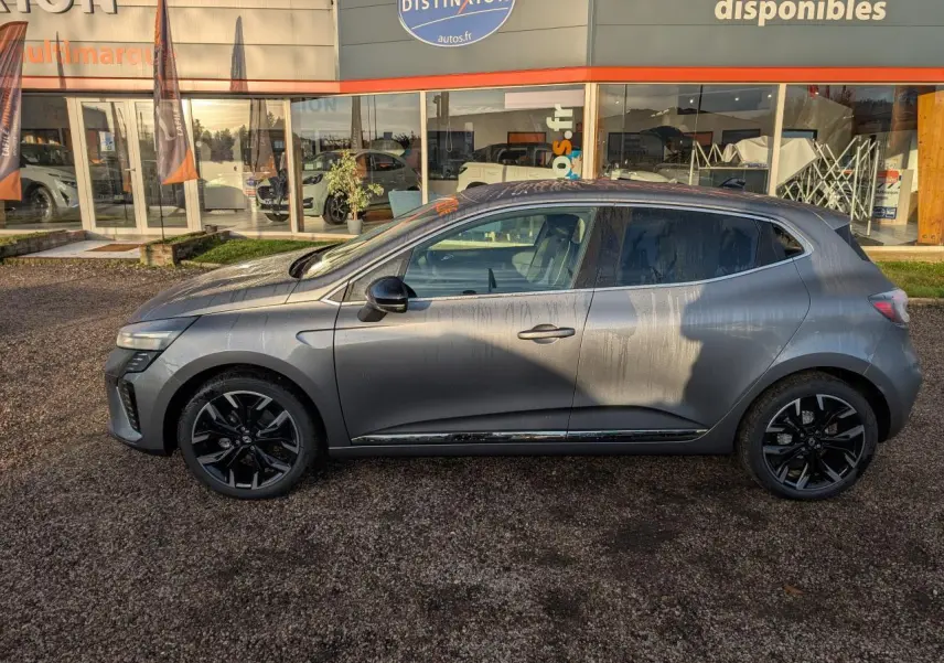 Renault Clio 2025 gris schiste vue de profil côté gauche avec jantes alliage noires et détails chromés extérieurs.