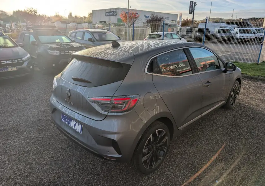 Renault Clio gris schiste vue 3/4 arrière droit, avec jantes alliage noir monastella et antenne requin noire brillante.