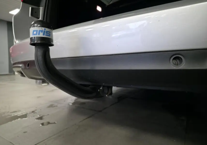 Gros plan sur l'attelage démontable noir sous le pare-chocs arrière gris platine d'une Renault Talisman Estate 2018.