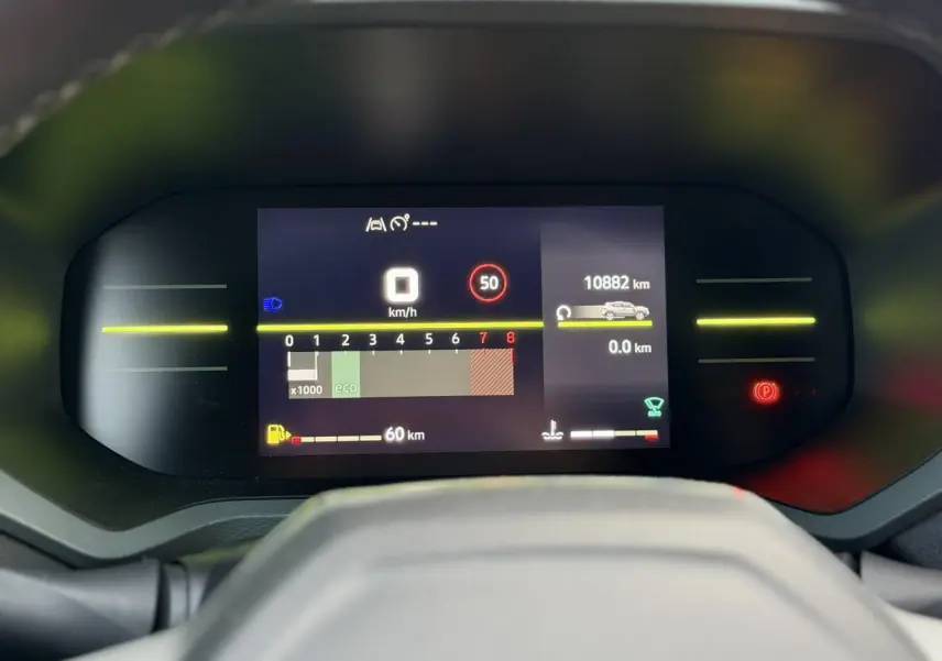 Tableau de bord digital du Dacia Duster 2025, affichage vitesse et kilométrage, vue frontale centrée.
