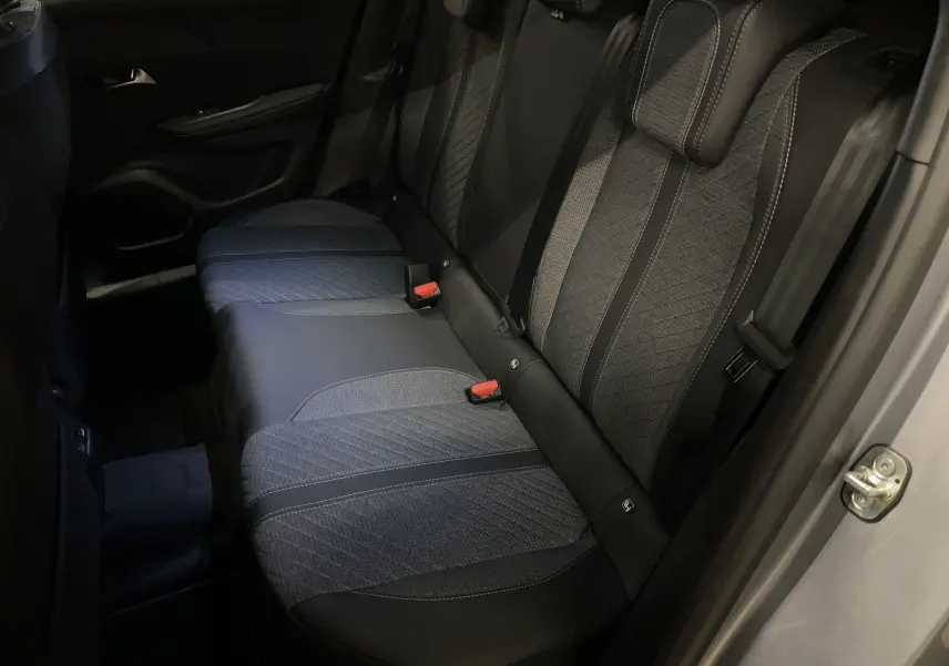 Vue intérieure côté droit des sièges arrière en tissu et cuir noir du Peugeot 2008 gris Artense 2025.