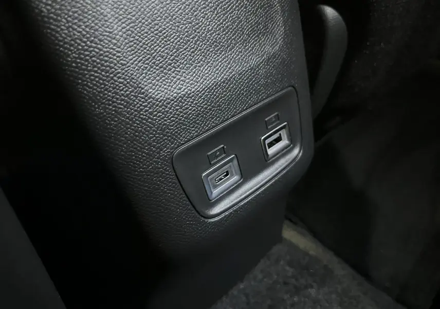 Gros plan sur les ports USB arrière intégrés dans la console centrale noire du Peugeot 2008 gris Artense 2025.
