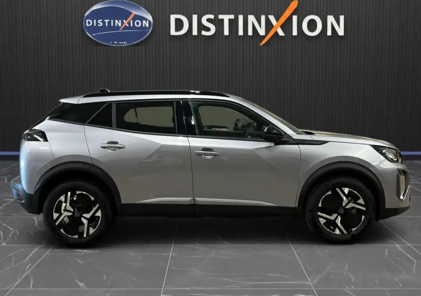 Peugeot 2008 gris Artense métal en profil droit, soulignant ses jantes bicolores et toit noir panoramique.