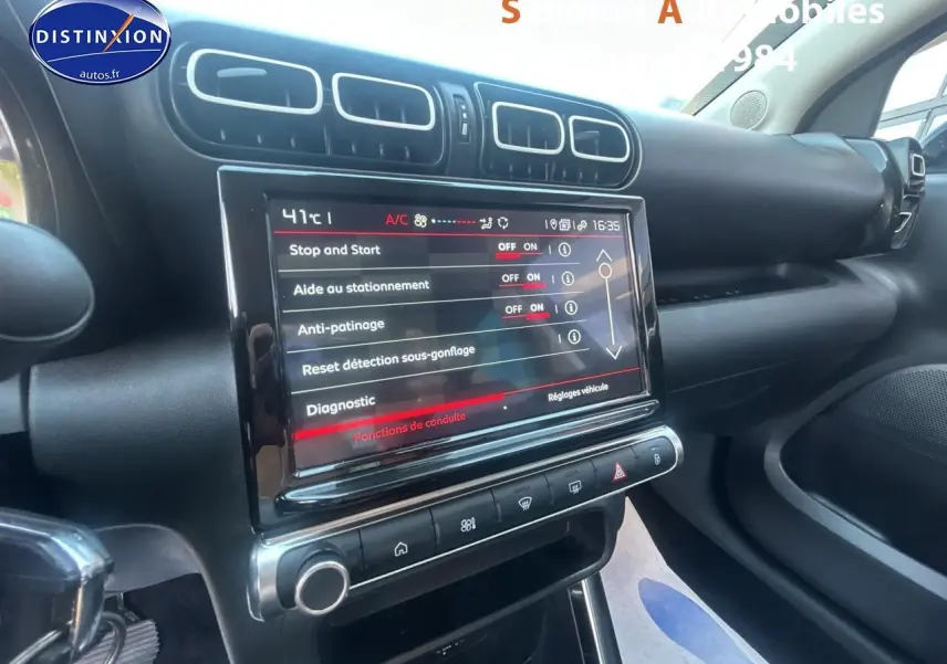 Vue intérieure du tableau de bord de la Citroën C3 Aircross gris foncé, avec écran tactile central et commandes visibles.
