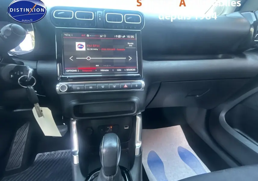 Vue intérieure centrée sur la console centrale et la tablette tactile du Citroën C3 Aircross gris foncé de 2021.