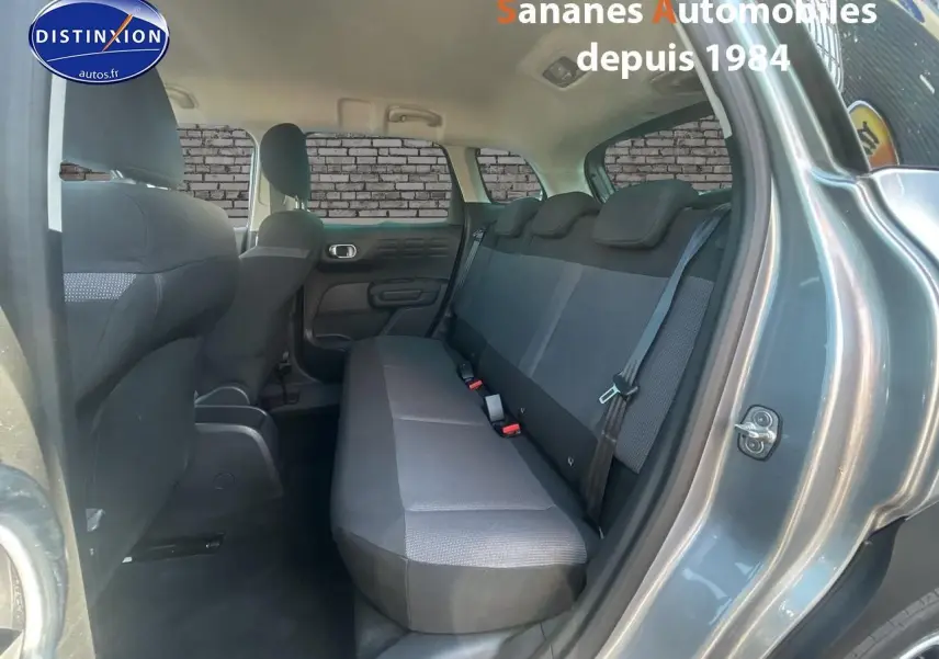 Vue intérieure arrière côté droit du Citroën C3 Aircross gris foncé, montrant la banquette arrière en tissu Mica Grey.