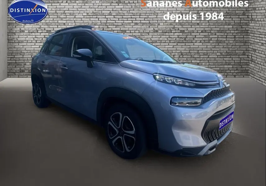 Vue 3/4 avant droit d'un Citroën C3 Aircross gris foncé avec jantes 16 pouces et calandre distinctive.