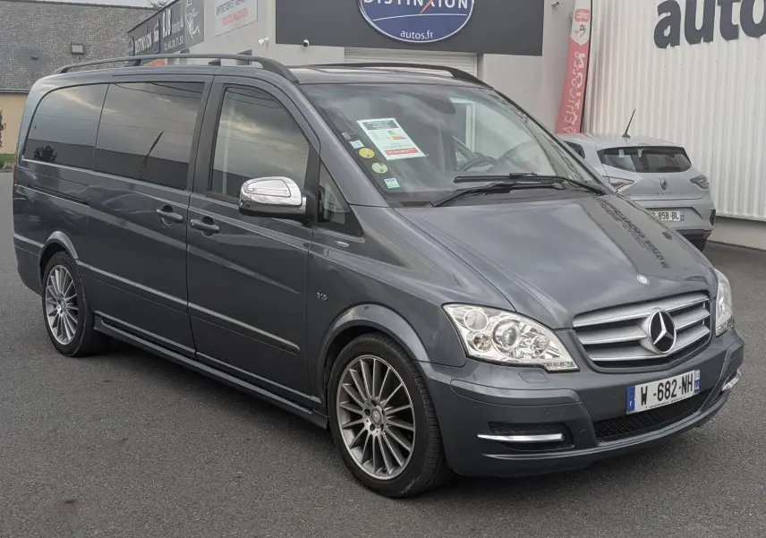 Mercedes Viano gris en 3/4 avant droit avec jantes alliage et vitres arrière surteintées, stationné devant un garage