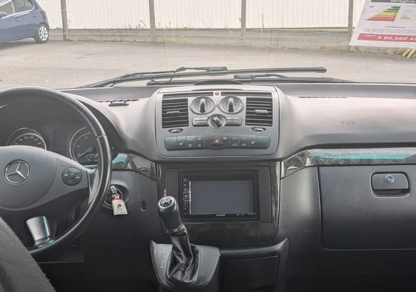 Vue intérieure avant du Mercedes Viano 3.0 CDI gris, tableau de bord noir avec écran tactile et volant cuir.