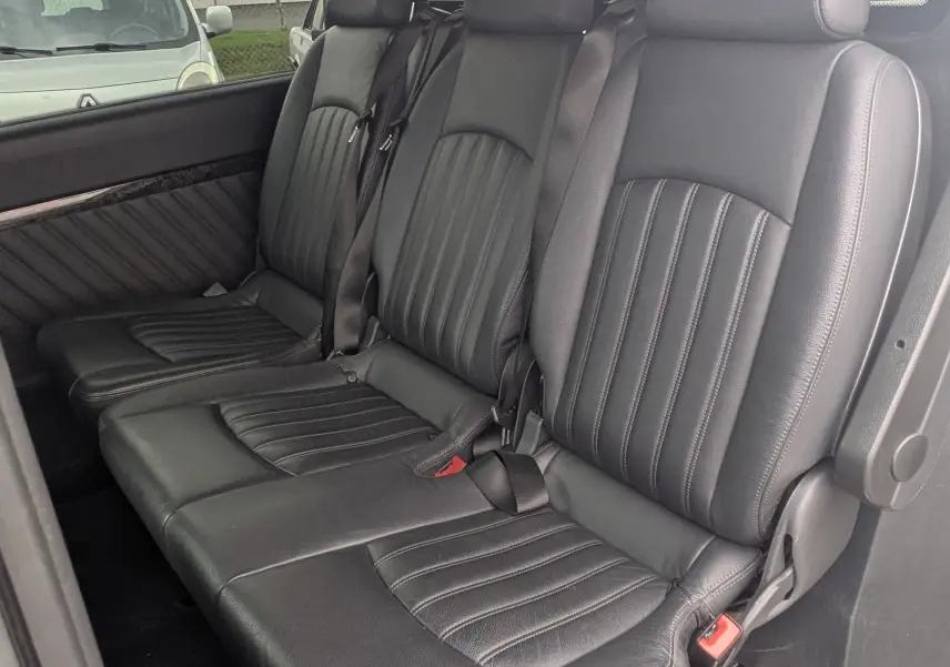 Vue intérieure côté droit du Mercedes Viano 3.0 CDI avec sièges en cuir noir et seuil de porte Mercedes-Benz visible.
