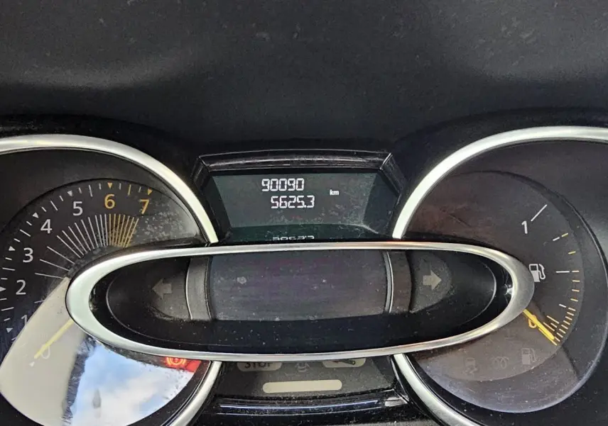 Gros plan sur le tableau de bord de la Renault Clio IV grise, affichant le compteur kilométrique et le niveau de carburant.