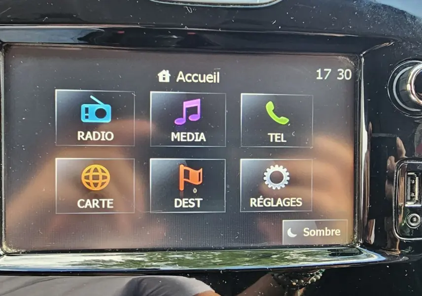 Écran tactile central de la Renault Clio IV grise de 2015 affichant les options radio, média, téléphone, carte, destination et réglages.