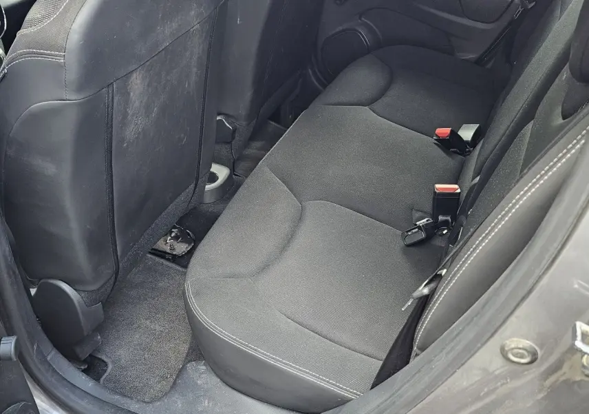 Vue intérieure côté arrière droit montrant la banquette arrière grise d'une Renault Clio IV 2015 finition Zen.