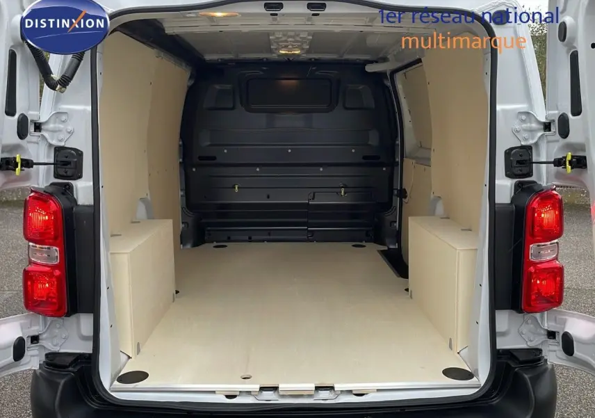 Vue arrière du Peugeot Expert Fourgon blanc icy 2025 avec portes ouvertes montrant l'espace de chargement aménagé en bois clair.