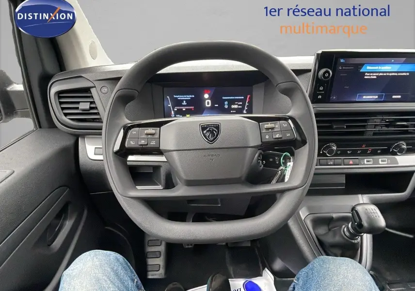 Vue intérieure centrée sur le volant Peugeot Expert Fourgon blanc Icy 2025 avec tableau de bord numérique et levier de vitesses manuel.