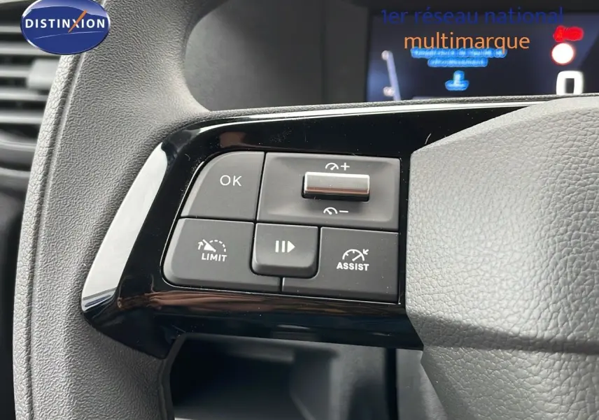 Gros plan sur les commandes de régulateur de vitesse au volant gris du Peugeot Expert Fourgon blanc Icy 2025.