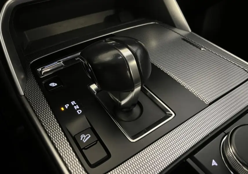 Gros plan sur le levier de vitesses automatique du Mazda CX-60 2023 avec finition noire et inserts argentés.