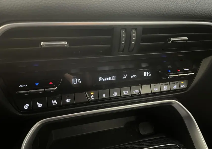 Panneau de commande de la climatisation bi-zone du Mazda CX-60 blanc 2023, avec affichage digital et commandes tactiles.