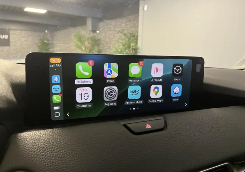 Écran central tactile du Mazda CX-60 2023 affichant Apple CarPlay avec plusieurs applications visibles.