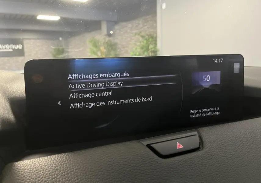 Écran central tactile du tableau de bord du Mazda CX-60 blanc, affichant les options d'affichage embarqué.