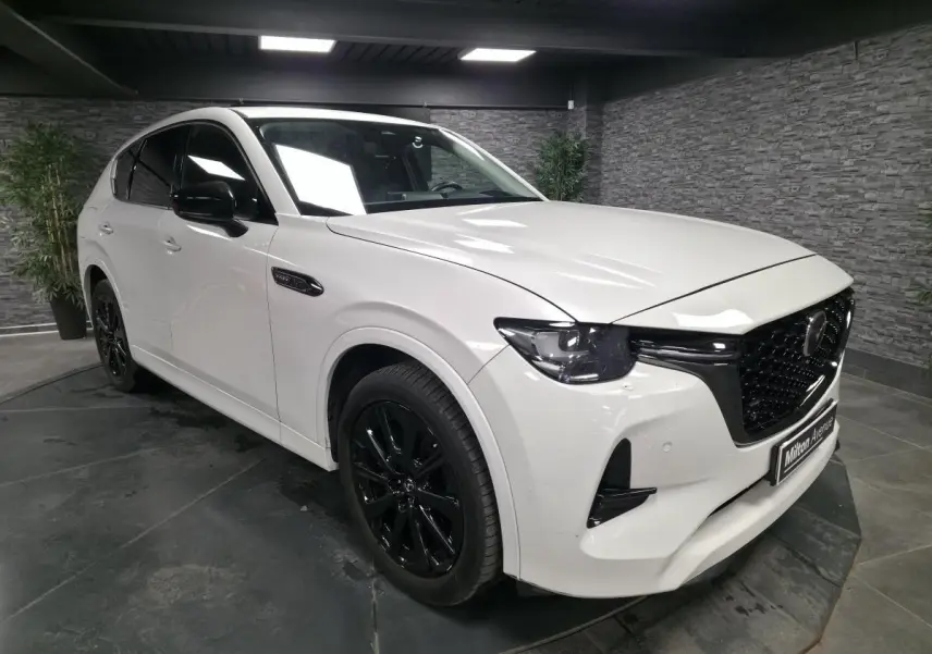 Vue 3/4 avant droite du Mazda CX-60 blanc Arctic White avec jantes alliage noires et calandre Piano Black.