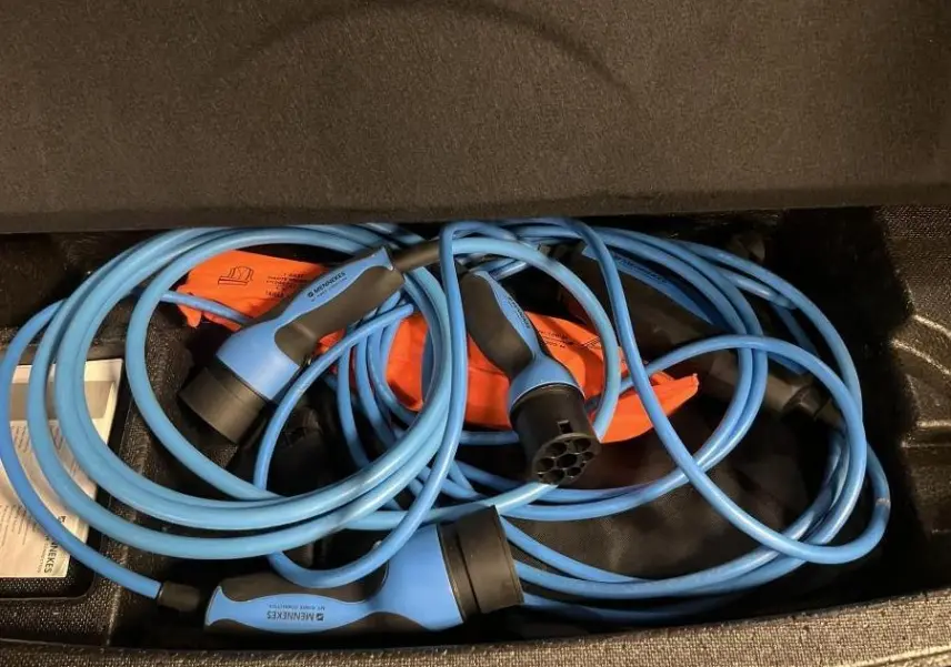 Câbles de recharge bleu pour Mazda CX-60 hybride rechargeable rangés dans le coffre noir.