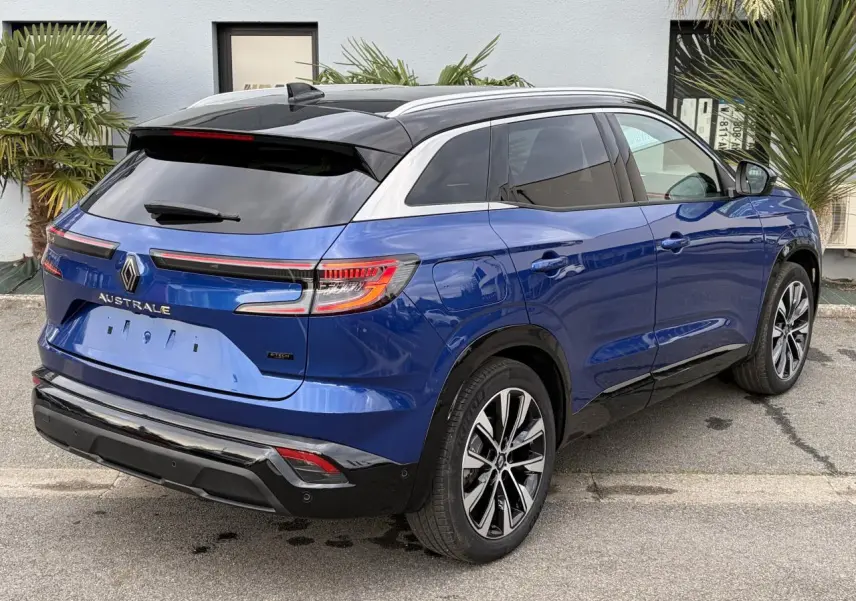 Vue 3/4 arrière droite du Renault Austral bleu Iron avec toit noir panoramique et jantes alliage 19 pouces.