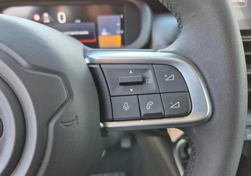 Gros plan sur les commandes au volant côté droit du Jeep Avenger noir 2024, avec boutons de volume et téléphone.