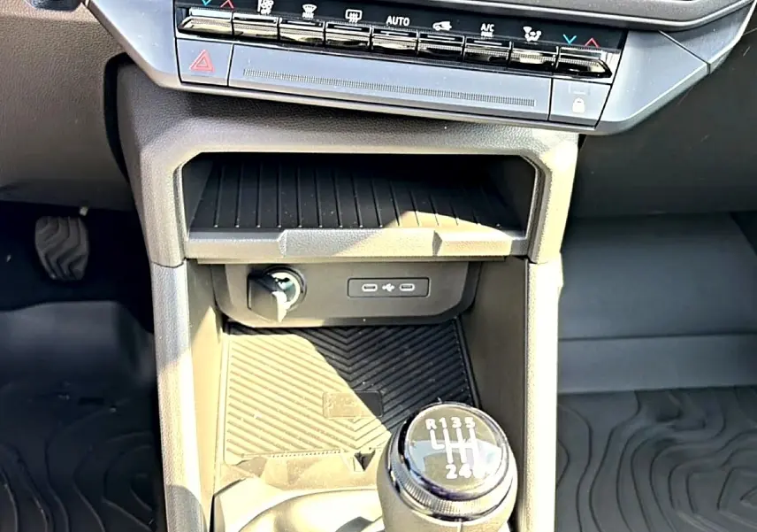 Gros plan intérieur sur la console centrale noire du Dacia Bigster 2026, avec levier de vitesse manuel et commandes climatisation.