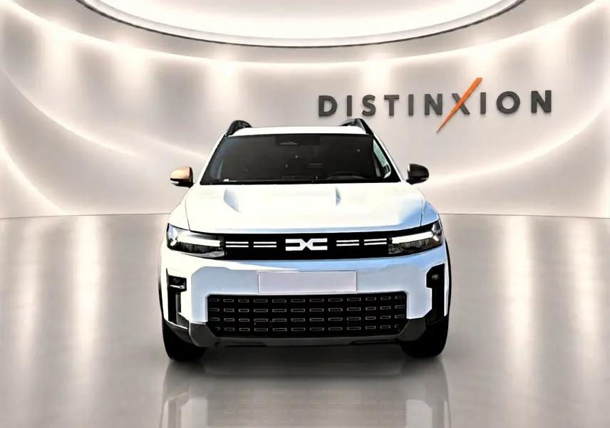 Vue de face du Dacia Bigster blanc avec calandre noire et logo distinctif, sur fond lumineux "Distinxion".
