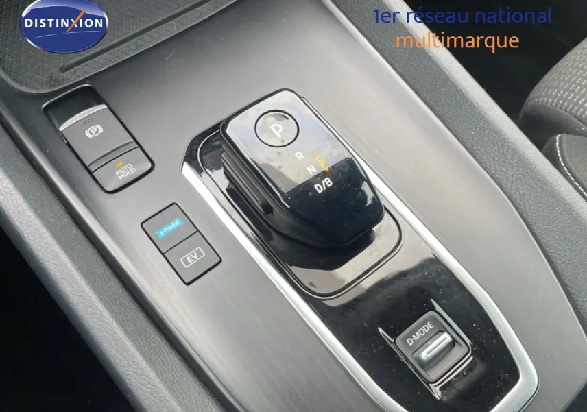 Gros plan sur la console centrale du Nissan Qashqai 2023 noir métal, montrant la commande de boîte automatique et les boutons EV et D-Mode.