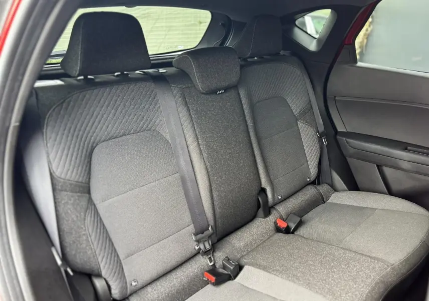 Vue intérieure sur la banquette arrière grise du Renault Captur 2025, avec ceintures et appuie-têtes visibles.