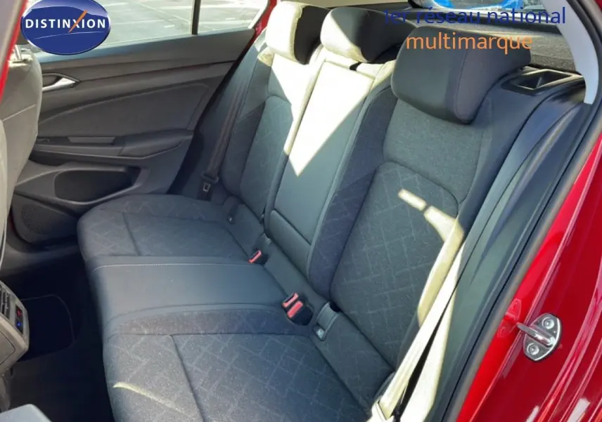 Vue intérieure sur la banquette arrière grise de la Volkswagen Golf VIII rouge Roi Metal, avec ceinture de sécurité visible.