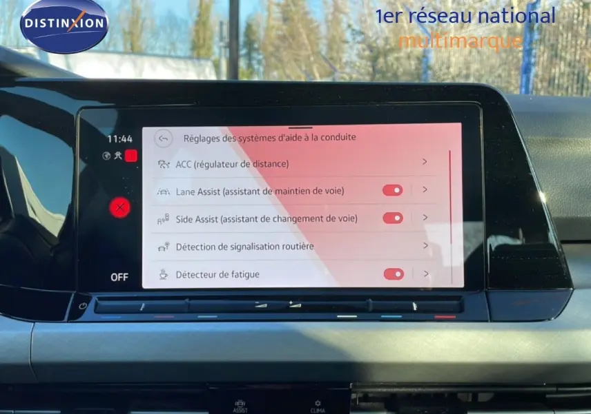 Écran tactile central de la Volkswagen Golf VIII rouge, affichant les réglages des aides à la conduite.