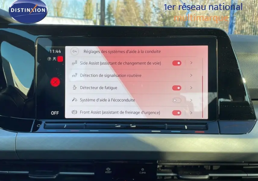 Écran central tactile affichant les réglages d’aide à la conduite dans l’habitacle d’une Volkswagen Golf VIII rouge.