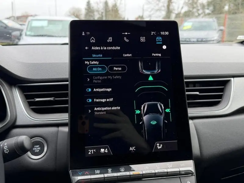 Écran tactile central du tableau de bord du Renault Captur 2025 affichant les aides à la conduite, intérieur noir.