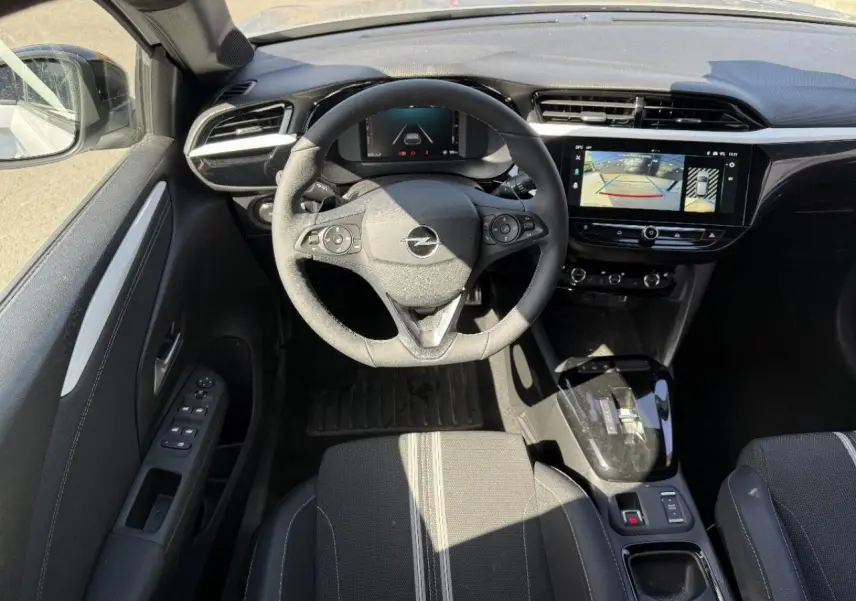 Vue intérieure du poste de conduite de l’Opel Corsa 2025, volant multifonction et écran tactile avec caméra de recul.