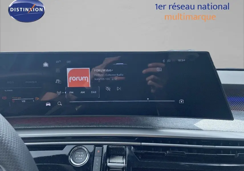 Tableau de bord du Peugeot 5008 Hybrid 2025 avec écran tactile central affichant une radio numérique, vue intérieure frontale.