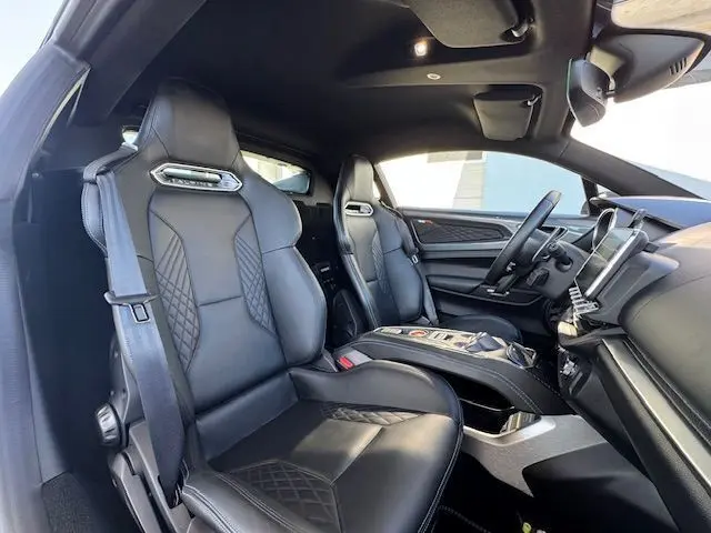 Intérieur de l'Alpine A110 1.8T 252 Légende 2021, vue côté droit sur sièges cuir noir Sabelt et tableau de bord moderne.