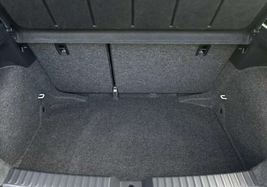 Coffre vide de la SEAT IBIZA TSI 115 Xcellence 2025, vue intérieure montrant la moquette grise et les fixations ISOFIX.