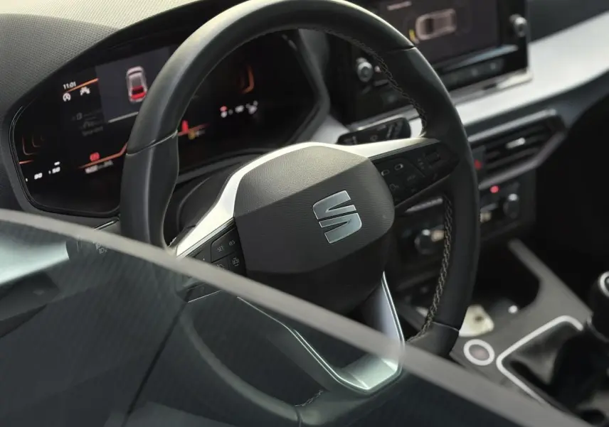 Vue rapprochée du volant noir de la SEAT Ibiza TSI 115 Xcellence 2025 avec tableau de bord digital et commandes intégrées.