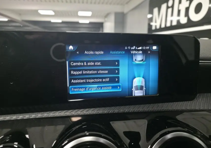 Écran tactile du système multimédia MBUX de la Mercedes Classe A blanc, affichant les aides à la conduite.