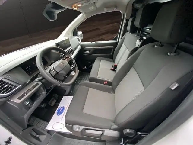 Vue intérieure côté conducteur du Citroën Jumpy XL 2025, sièges tissu noir et gris avec tableau de bord moderne.