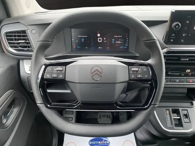 Vue intérieure centrée sur le volant noir du Citroën Jumpy XL 2025 avec tableau de bord numérique et commandes intégrées.
