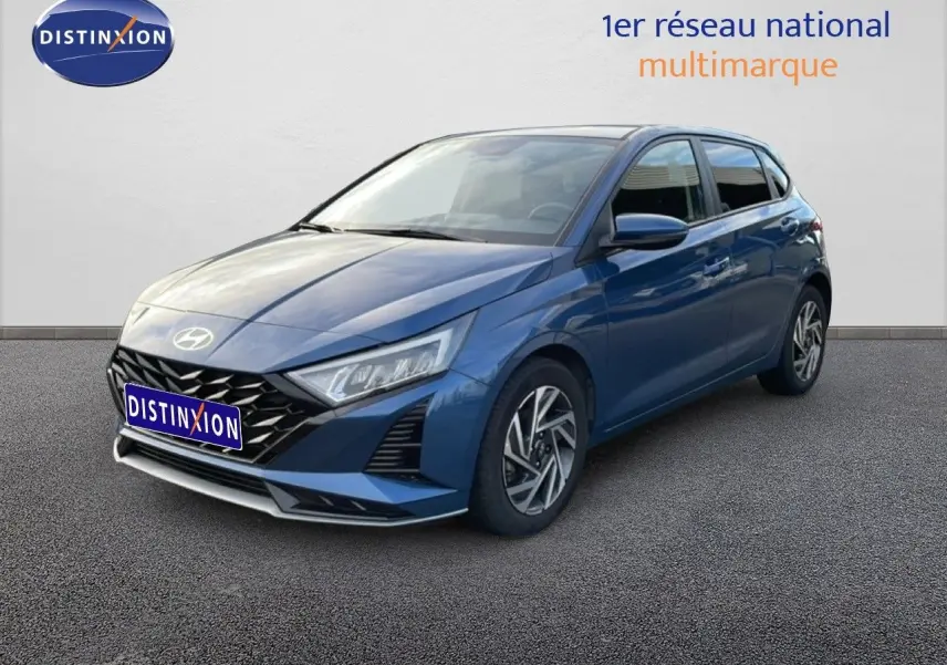 Vue 3/4 avant droit d'une Hyundai i20 2025 bleu vibrant metal avec calandre noire et phares LED anguleux.