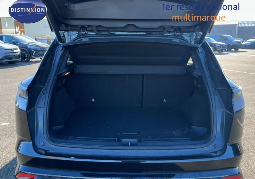 Coffre ouvert vu de l'arrière d'un Renault Austral noir étoile métal 2023, montrant l'espace de chargement vide.