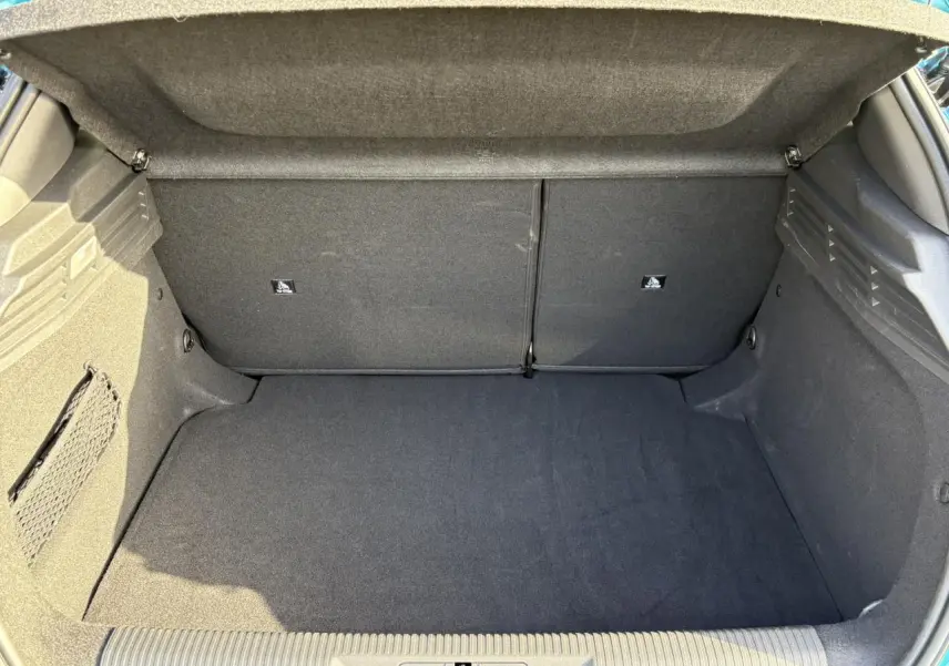 Vue intérieure du coffre spacieux et propre de la Peugeot 308 Hybrid 145 e-DCS6 Bleu Obsession, avec banquette arrière rabattue.