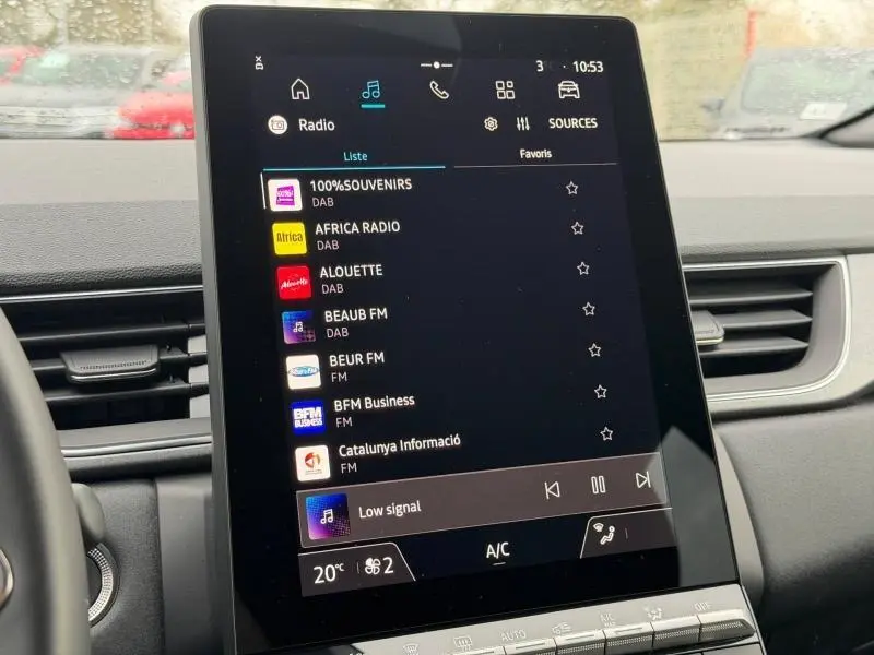 Écran tactile central du Renault Captur 2025 affichant la liste des radios, intérieur avec tableau de bord noir.